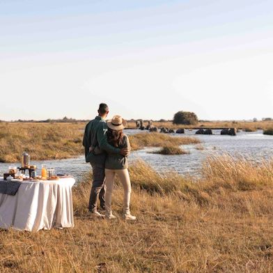 Couple at romantic sundowner Wilderness Botswana